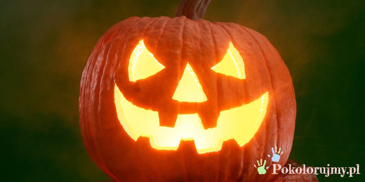 Wydrążona dynia z uśmiechniętą twarzą na Halloween, oświetlona od środka.